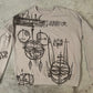 Black painted characters on a white sweatshirt.